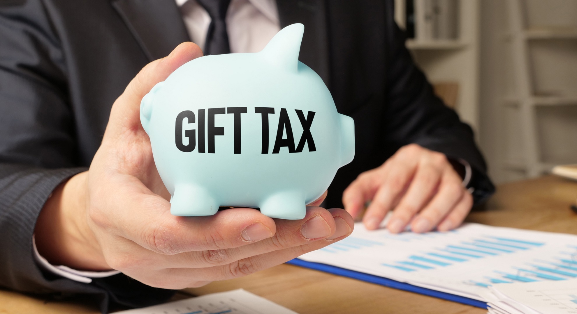 Piggy bank that says Gift Tax with tax documents on the table