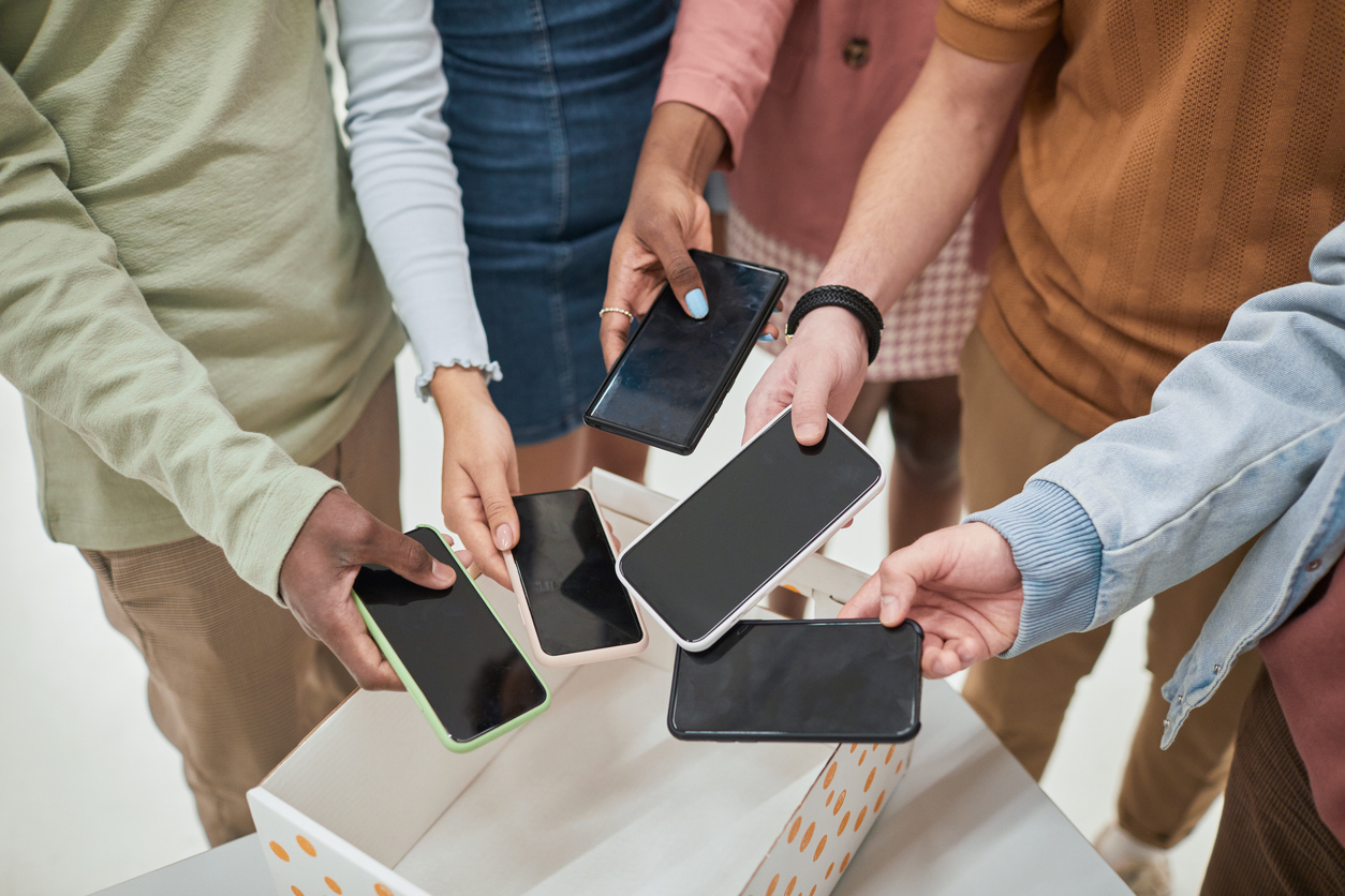 Students putting cellphones in basket before class.