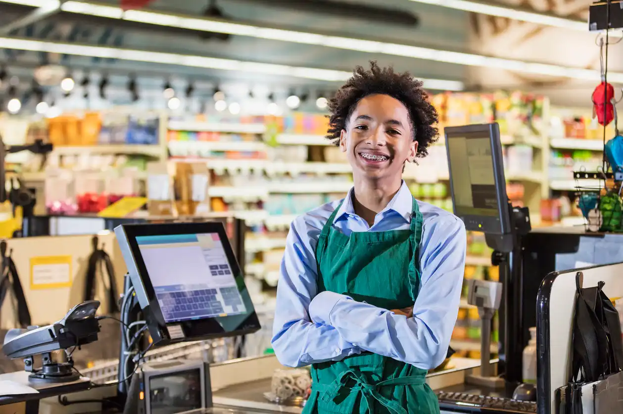 Teenager at grocery store job smiling